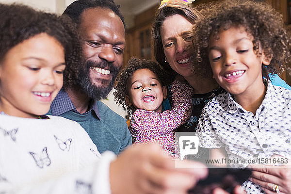 Happy multiethnic family using smart phone