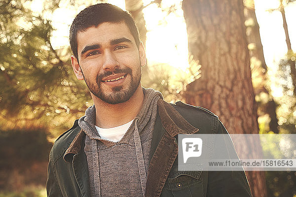 Porträt selbstbewusster junger Mann im Wald