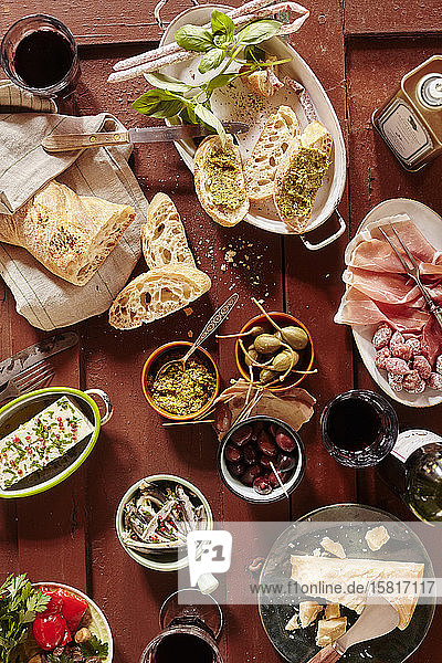 Bruschetta mit Pesto  Mini-Salami  Oliven  Parmesan  Olivenöl  Riesenkapern und Rotwein