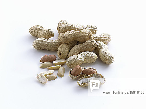 Erdnüsse mit und ohne Schale auf weißem Hintergrund