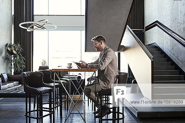 Businessman using tablet in hotel lobby