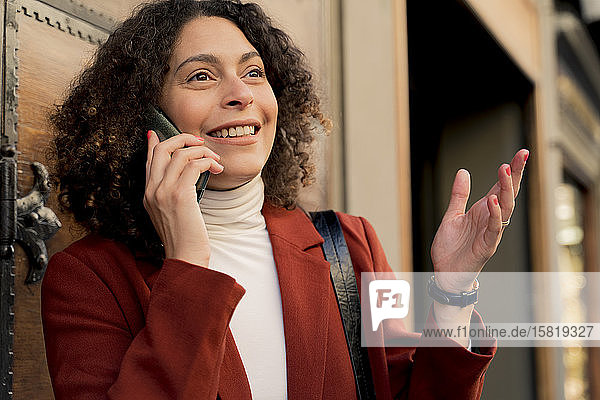 Porträt einer lächelnden Frau am Telefon in der Stadt