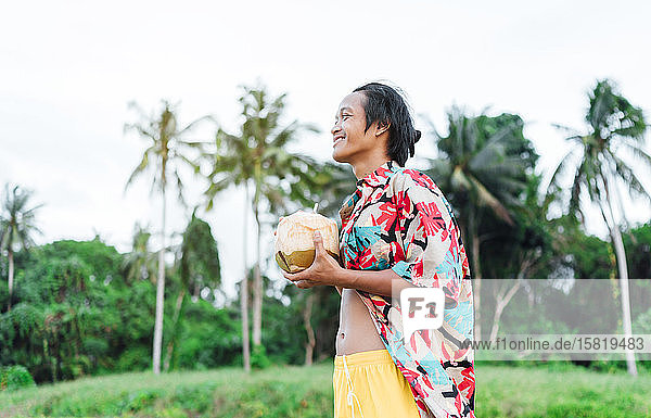 Glücklicher Mann genießt frisches Kokosnusswasser  Insel Borneo  Malaysia