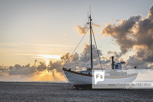 Dänemark  Slettestrand  Fischerboot bei Sonnenuntergang am sandigen Küstenstrand
