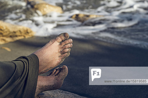 Nackte Füße mit Sand  am Strand in der Nähe von Triopetra  Kreta  Griechenland sitzend