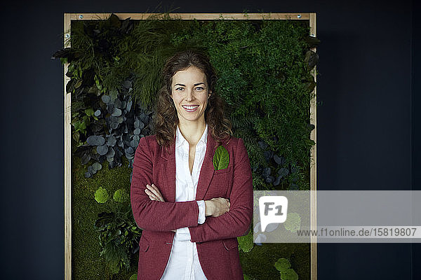 Portait of smiling businesswoman in green office