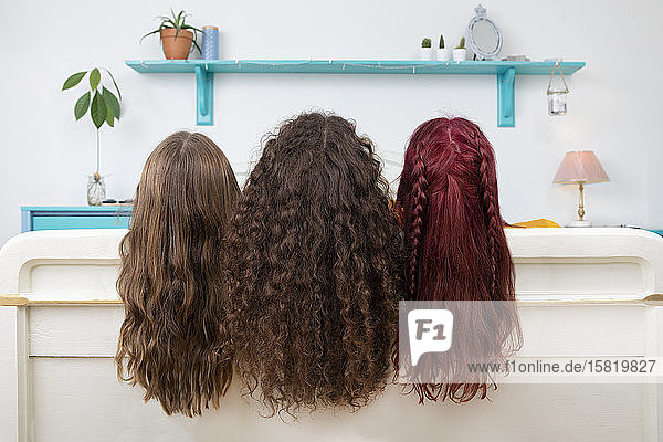 Rückenansicht von drei Schwestern mit langen Haaren