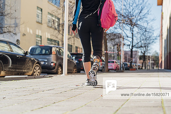 Sportliche junge Frau mit Beinprothese beim Spaziergang in der Stadt