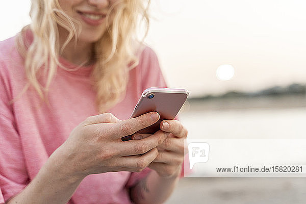 Nahaufnahme einer jungen Frau  die ein Smartphone im Freien benutzt