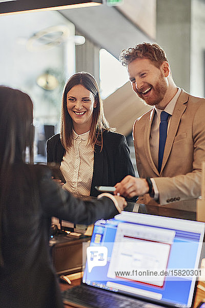 Business people paying at hotel reception