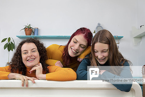 Portrait of three happy sisters at home
