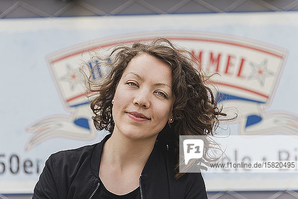 Porträt einer lächelnden brünetten Frau vor einem Retro-Bistro