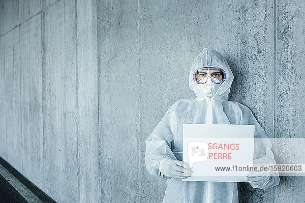 Porträt eines Mannes in Schutzkleidung mit einem Schild