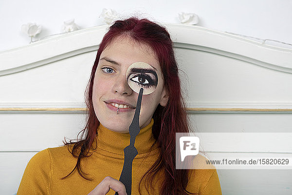 Portrait of redheaded woman with paper mask