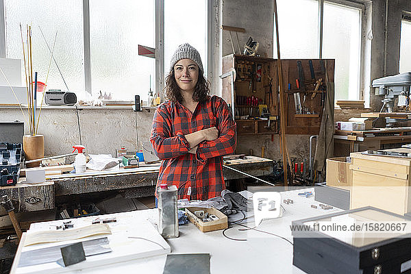 Porträt einer selbstbewussten Handwerkerin in ihrer Werkstatt