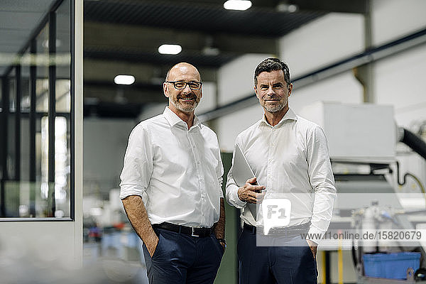 Portrait of two confident businessmen in a factory