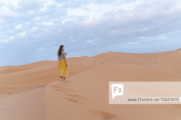 Young woman on sand dune in Sahara Desert  Merzouga  Morocco