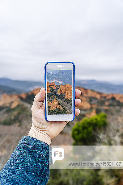 Mann hält ein Smartphone mit einem Bild von Mina de Oro Romana Las Medulas Kastilien und León Spanien