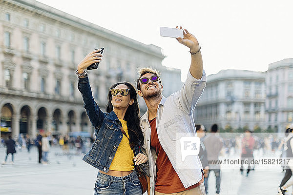 Happy young couple taking selfies in the city  Milan  Italy