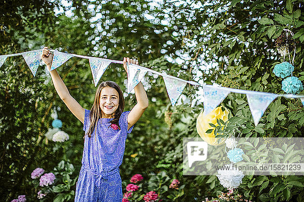 Porträt eines Mädchens  das den Garten für eine Geburtstagsfeier dekoriert