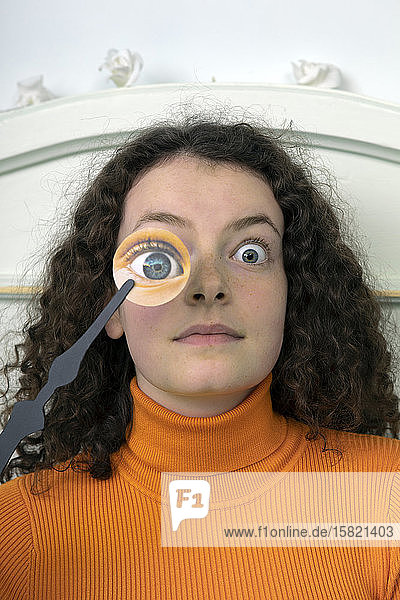 Portrait of starring young woman with paper mask