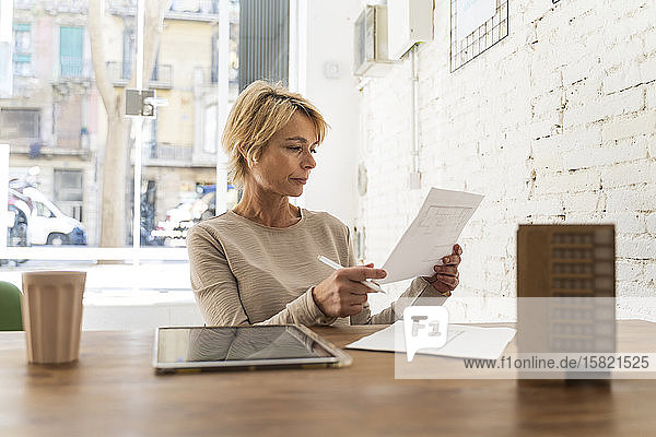 Reife Frau arbeitet am Schreibtisch im Architekturbüro