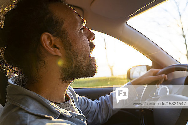 Man in car at sunset