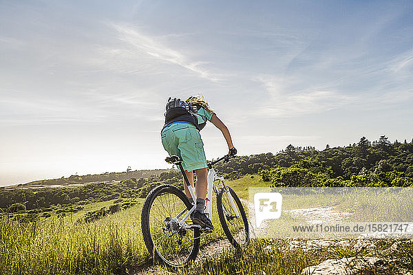 Female mountainbiker riding down narrow trail  Santa Cruz  California  USA