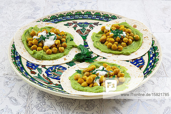 Fladenbrotteller mit Avocadopüree Kurkuma-Kichererbsen Joghurt und Petersilie