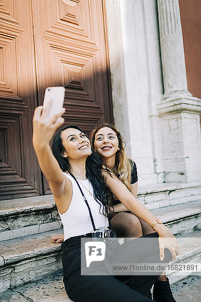 Porträt von zwei jungen Frauen  die sich mit einem Smartphone selbstständig machen  Lissabon  Portugal