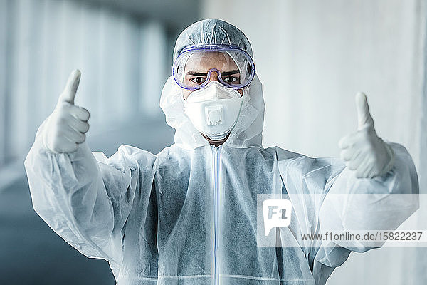 Porträt eines Mannes in Schutzkleidung mit Daumen nach oben