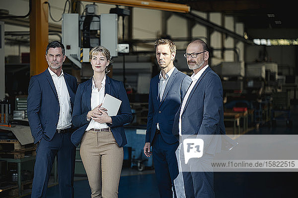 Confident business team standing in a factory