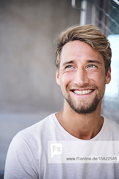 Porträt eines lächelnden jungen Mannes mit weißem T-Shirt