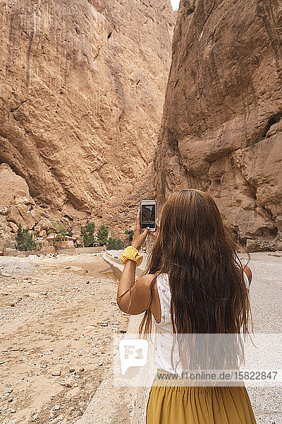 Rückansicht einer jungen Frau die mit einem Smartphone fotografiert Ouarzazate Marokko