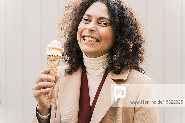 Porträt einer glücklichen Frau  die eine Eistüte isst