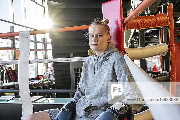 Porträt einer Boxerin im Fitnessstudio in der Ringecke sitzend