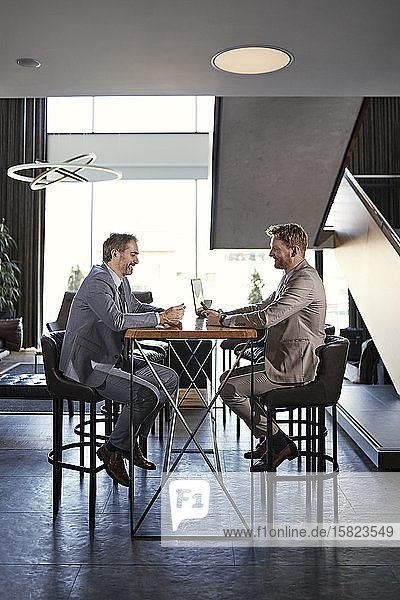 Two businessmen having a meeting in hotel lobby