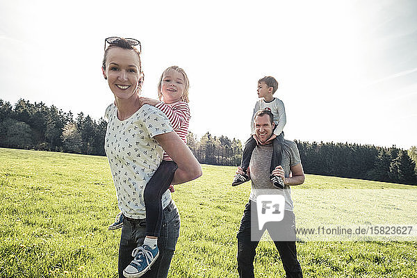 Happy family with two kids on a meadow in spring