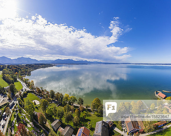 Germany  Bavaria  Chieming  Clouds over Chiemsee lake and lakeshore houses on sunny autumn day