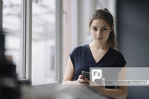 Porträt einer jungen Geschäftsfrau mit digitalem Tablett im Büro