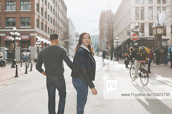 Happy couple walking down a city street  Vancouver  Canada