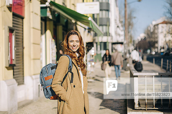 Porträt einer glücklichen jungen Frau mit Rucksack in der Stadt  Lissabon  Portugal
