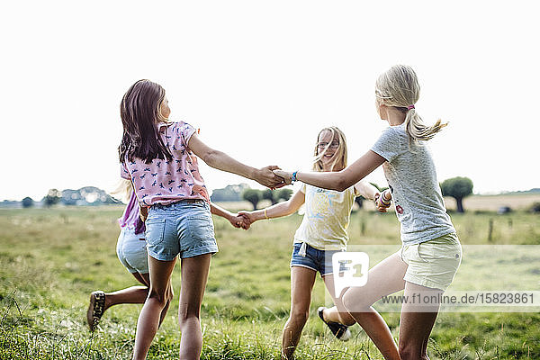 Glückliche Mädchen tanzen gemeinsam auf einem Feld