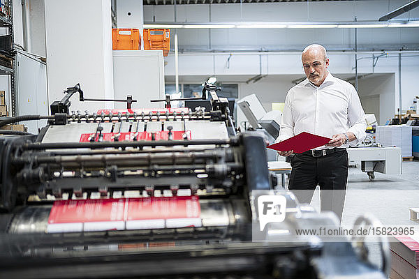 Businessman in a printing plant checking product