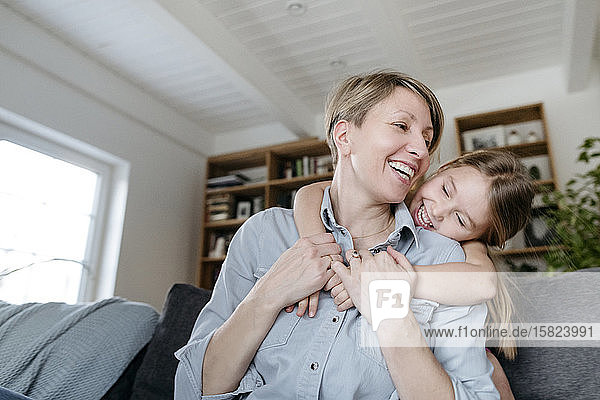 Porträt einer glücklichen Mutter und einer kleinen Tochter  die sich zu Hause amüsieren