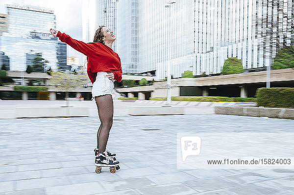 Happy young woman roller skating in the city