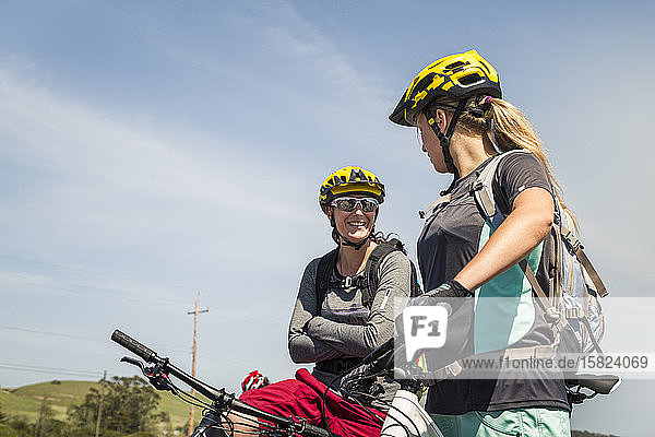 Two women on mountain bikes having a break