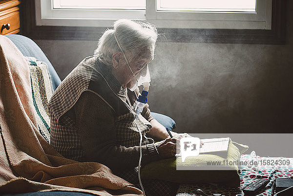 Ältere Frau benutzt Inhalator zu Hause