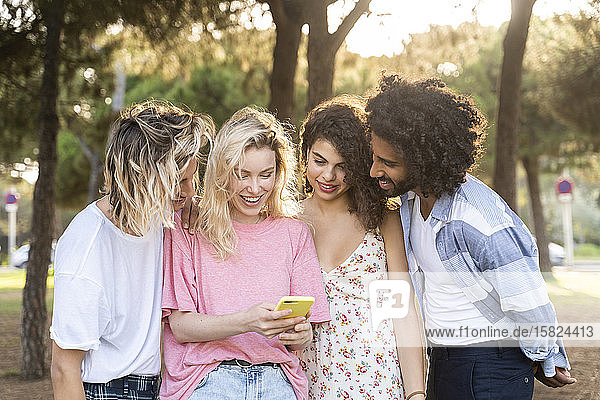 Group of friends using smartphone outdoors