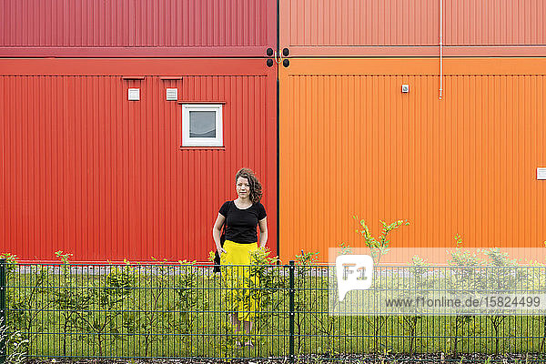 Porträt einer Frau  die vor einem bunten zweistöckigen Containergebäude steht